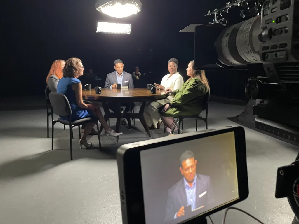 Multi-person roundtable discussion with professional sound setup